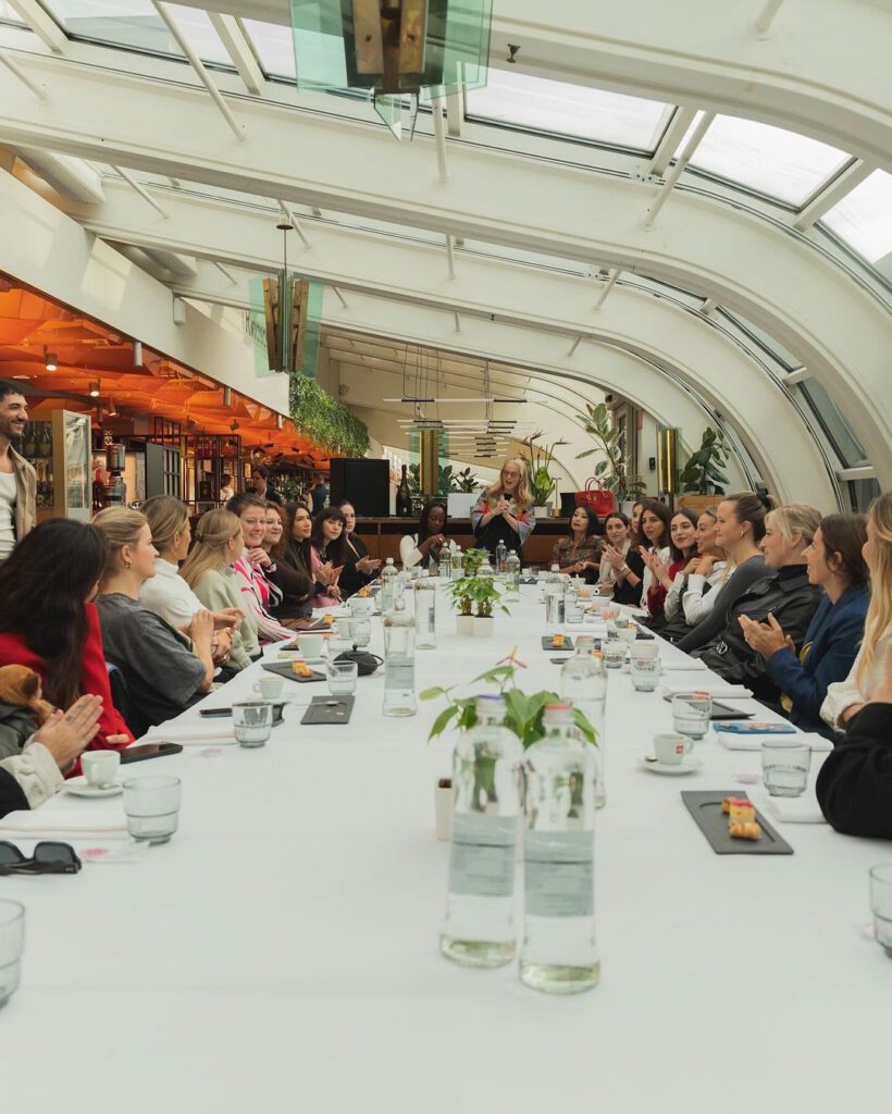 Evento team building de gran tamaño dentro de empresa, mesa llena de mujeres
